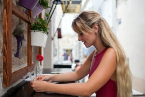 Beautiful tourist woman in local restaurant outdoor looking at menu, travel lifestyle